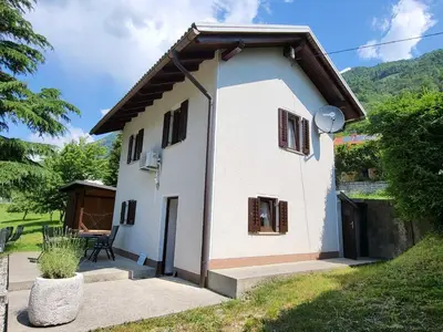 a small white house with a table in a yard at Peaceful Countryside Holiday Home with Terrace - One Bedroom Holiday Home with Terrace in Tolmin