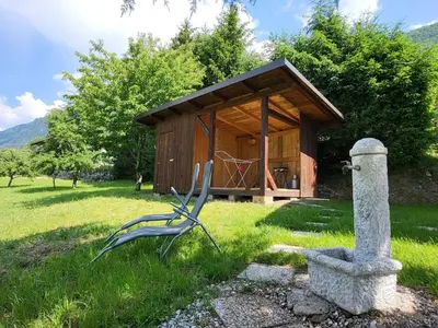 a chair in the grass in front of a small building at Peaceful Countryside Holiday Home with Terrace - One Bedroom Holiday Home with Terrace in Tolmin