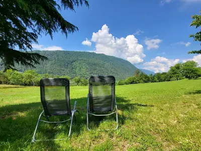 two chairs sitting in the grass in a field at Peaceful Countryside Holiday Home with Terrace - One Bedroom Holiday Home with Terrace in Tolmin