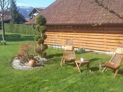 two chairs and a table in a yard at Sunny and Comfortable Apartment with Terrace and Garden - Two Bedroom Apartment with Terrace in Rečica ob Savinji