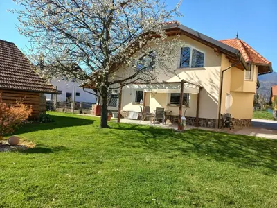 a house with a tree in the yard at Sunny and Comfortable Apartment with Terrace and Garden - Two Bedroom Apartment with Terrace in Rečica ob Savinji