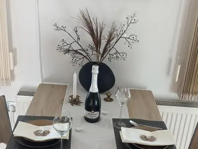 a table with a bottle of wine and two glasses at Sunny and Comfortable Apartment with Terrace and Garden - Two Bedroom Apartment with Terrace in Rečica ob Savinji