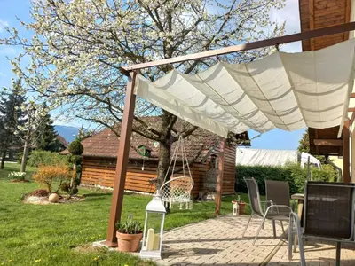 a patio with a white canopy and chairs in a yard at Sunny and Comfortable Apartment with Terrace and Garden - Two Bedroom Apartment with Terrace in Rečica ob Savinji
