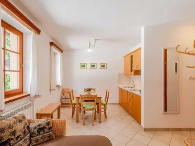a kitchen and dining room with a table and chairs at Log pod Mangartom Amazing Apartment with Balcony - One Bedroom Apartment with Balcony in Log pod Mangartom