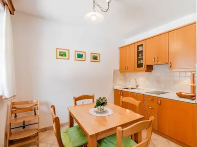 a kitchen and dining room with a wooden table and chairs at Log pod Mangartom Amazing Apartment with Balcony - One Bedroom Apartment with Balcony in Log pod Mangartom