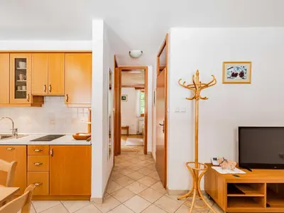 a kitchen with a cross on a table and a tv at Log pod Mangartom Amazing Apartment with Balcony - One Bedroom Apartment with Balcony in Log pod Mangartom