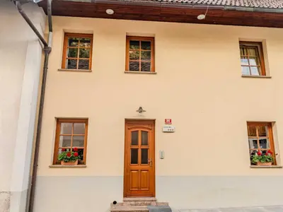 a house with a wooden door and windows at Log pod Mangartom Amazing Apartment with Balcony - One Bedroom Apartment with Balcony in Log pod Mangartom