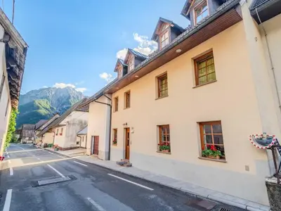 a street in a town with mountains in the background at Log pod Mangartom Amazing Apartment with Balcony - One Bedroom Apartment with Balcony in Log pod Mangartom