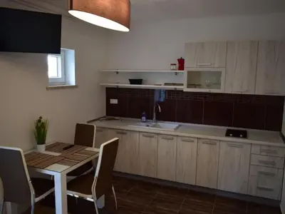a kitchen with a table and a sink and a table and chairs at Standard One Bedroom Apartment in Brežice