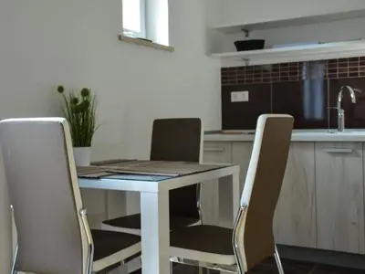 a kitchen with a table and chairs in a kitchen at Standard One Bedroom Apartment in Brežice