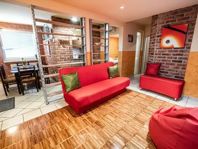 a living room with a red couch and a table at Elegant and Stylish Retreat Apartments with Terrace - Two Bedroom Apartment with Terrace in Brežice