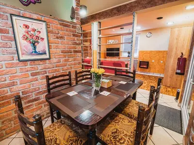 a dining room with a wooden table and chairs at Elegant and Stylish Retreat Apartments with Terrace - Two Bedroom Apartment with Terrace in Brežice