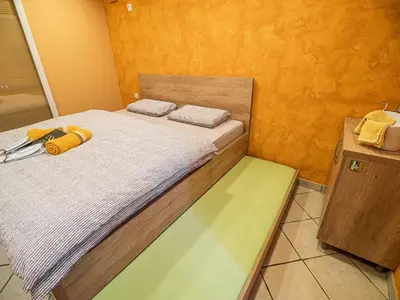 a bedroom with two beds and a wooden cabinet at Elegant and Stylish Retreat Apartments with Terrace - Two Bedroom Apartment with Terrace in Brežice