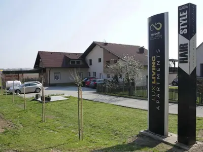 a sign in the grass in front of a house at Elegant and Stylish Retreat Apartments with Terrace - Two Bedroom Apartment with Terrace in Brežice