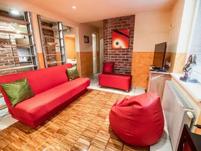 a living room with a red couch and a chair at Elegant and Stylish Retreat Apartments with Terrace - Two Bedroom Apartment with Terrace in Brežice