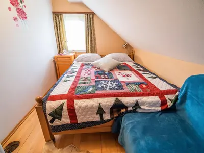 a bedroom with a bed with a quilt on it at Vivid Hillside Country House with Hot-Tub and Sauna - Two Bedroom Country House in Sevnica