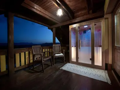 a room with two chairs on a balcony at night at Vivid Hillside Country House with Hot-Tub and Sauna - Two Bedroom Country House in Sevnica