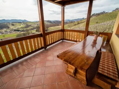 a wooden table on a balcony with a view at Vivid Hillside Country House with Hot-Tub and Sauna - Two Bedroom Country House in Sevnica