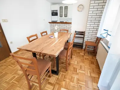 a dining room with a wooden table and chairs at Mountain View Haven Apartments - Two Bedroom Apartment with Balcony in Bovec