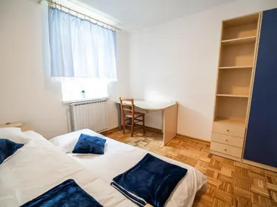 a bedroom with a bed and a desk and a window at Mountain View Haven Apartments - Two Bedroom Apartment with Balcony in Bovec