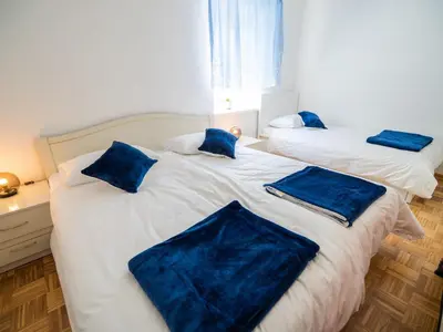 two beds in a room with blue pillows on them at Mountain View Haven Apartments - Two Bedroom Apartment with Balcony in Bovec