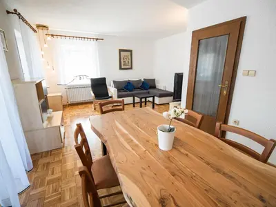 a living room with a wooden table and a couch at Mountain View Haven Apartments - Two Bedroom Apartment with Balcony in Bovec