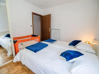 a bedroom with two beds with blue pillows on them at Mountain View Haven Apartments - Two Bedroom Apartment with Balcony in Bovec