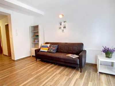 a brown leather couch in a living room at Stylish Retreat with BBQ and Modern Amenities near Terme - Three Bedroom Apartment in Dobova