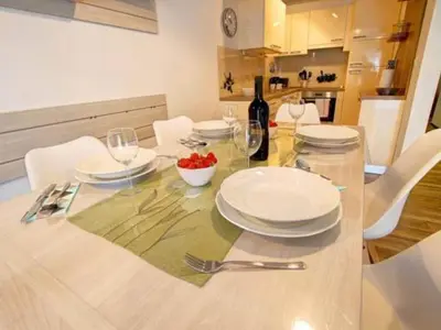 a dining table with white plates and wine glasses at Stylish Retreat with BBQ and Modern Amenities near Terme - Three Bedroom Apartment in Dobova