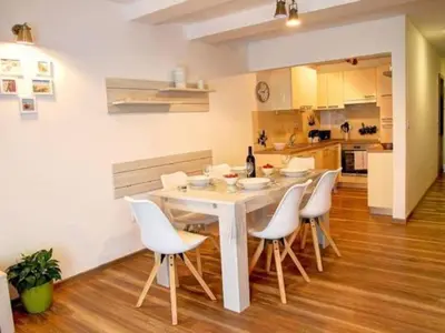 a kitchen and dining room with a white table and chairs at Stylish Retreat with BBQ and Modern Amenities near Terme - Three Bedroom Apartment in Dobova