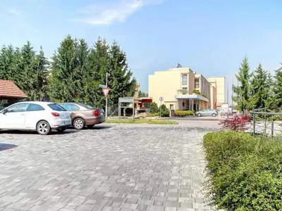 two cars parked in a parking lot next to a building at Stylish Retreat with BBQ and Modern Amenities near Terme - Three Bedroom Apartment in Dobova