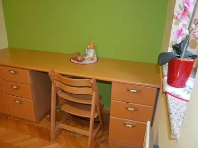 a desk with a chair next to a green wall at Two Bedroom Apartment with Balcony in Kranjska Gora