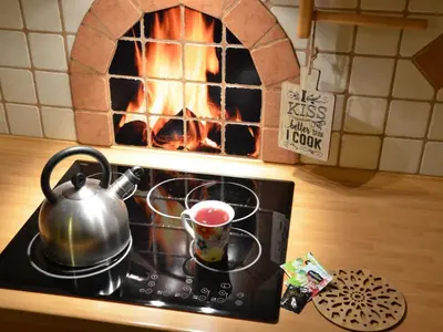 a tea kettle on a stove with a brick oven at Two Bedroom Apartment with Balcony in Kranjska Gora