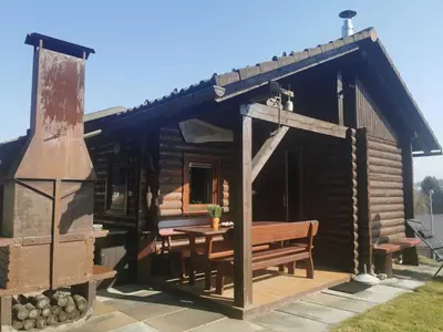 a log cabin with a table and a bench at Mountain Vista Cottage with Private Sauna - One Bedroom Cottage in Škofja Loka