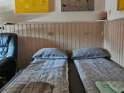 a room with two beds and a chair at Mountain Vista Cottage with Private Sauna - One Bedroom Cottage in Škofja Loka