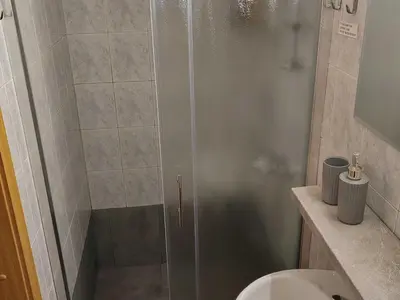a shower with a glass door in a bathroom at Mountain Vista Cottage with Private Sauna - One Bedroom Cottage in Škofja Loka