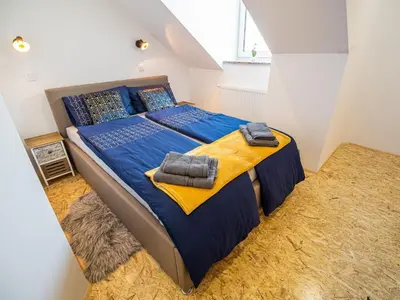 a bedroom with a large bed with blue sheets and pillows at City Modern and Vibrant Apartments Ljubljana - Standard One Bedroom Apartment in Ljubljana
