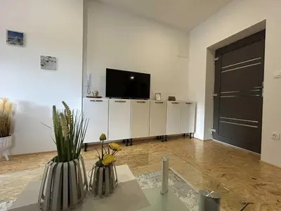 a living room with a tv and vases on a table at City Modern and Vibrant Apartments Ljubljana - Standard One Bedroom Apartment in Ljubljana
