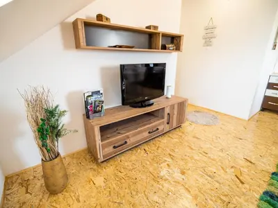a flat screen tv sitting on top of a wooden entertainment center at City Modern and Vibrant Apartments Ljubljana - Standard One Bedroom Apartment in Ljubljana