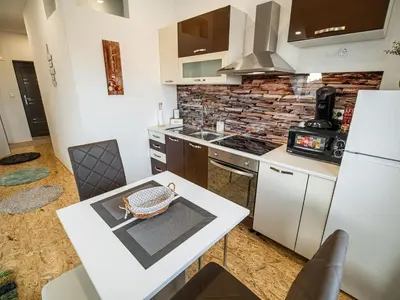 a kitchen with a white table and a stove at City Modern and Vibrant Apartments Ljubljana - Standard One Bedroom Apartment in Ljubljana