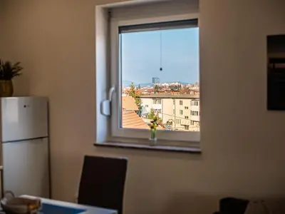 a window in a kitchen with a view of a city at City Modern and Vibrant Apartments Ljubljana - Standard One Bedroom Apartment in Ljubljana