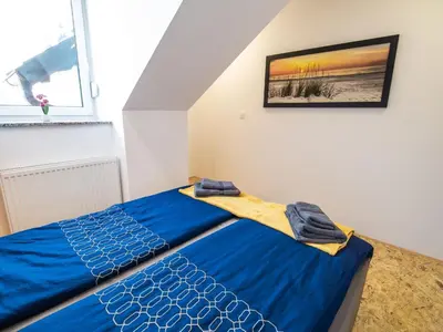a bedroom with a blue bed and a window at City Modern and Vibrant Apartments Ljubljana - Standard One Bedroom Apartment in Ljubljana