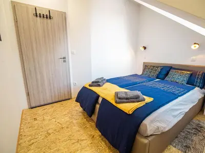 a bedroom with a bed with blue and yellow sheets at City Modern and Vibrant Apartments Ljubljana - Standard One Bedroom Apartment in Ljubljana