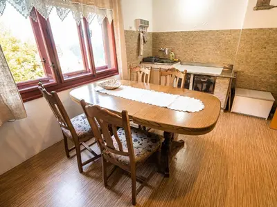 a dining room table with chairs and a kitchen at Bloomfield Retreat Country House with Sauna - Three Bedroom Country House in Rečica ob Savinji