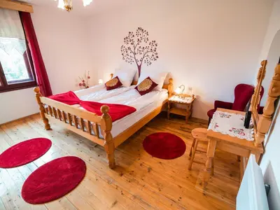 a bedroom with a bed and red rugs in it at Bloomfield Retreat Country House with Sauna - Three Bedroom Country House in Rečica ob Savinji