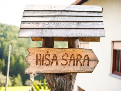 a wooden sign on a wooden pole with ahsana santa sign at Bloomfield Retreat Country House with Sauna - Three Bedroom Country House in Rečica ob Savinji