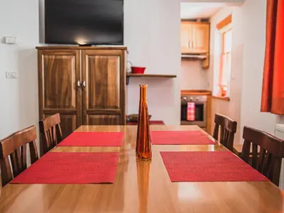 a dining room table with red mats on it at Bovec Picturesque Mountain Vista Residences - Two Bedroom Apartment in Bovec
