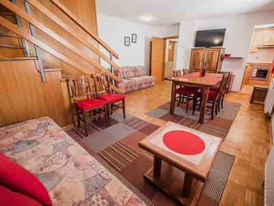 a living room with a table and chairs at Bovec Picturesque Mountain Vista Residences - Two Bedroom Apartment in Bovec