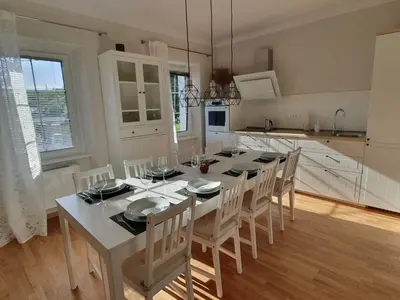 a kitchen with a white table and chairs in a room at Komen Getaway Holiday Home with Balcony - Four Bedroom Holiday Home with Balcony in Komen
