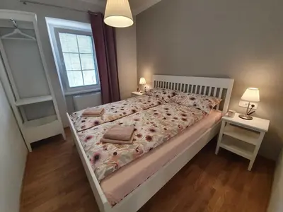 a bedroom with a bed and a night stand and a window at Komen Getaway Holiday Home with Balcony - Four Bedroom Holiday Home with Balcony in Komen
